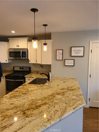 a kitchen with kitchen island a counter top space appliances and a view of living room
