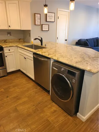 a kitchen with a sink and a washer dryer