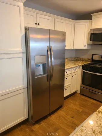 a kitchen with stainless steel appliances granite countertop a refrigerator and a stove