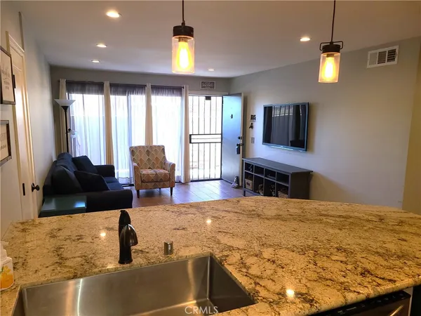 a spacious bedroom with a bed a couch and a chandelier