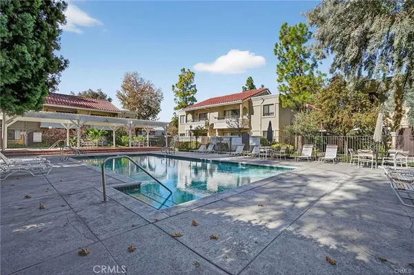 a view of house with swimming pool and a yard