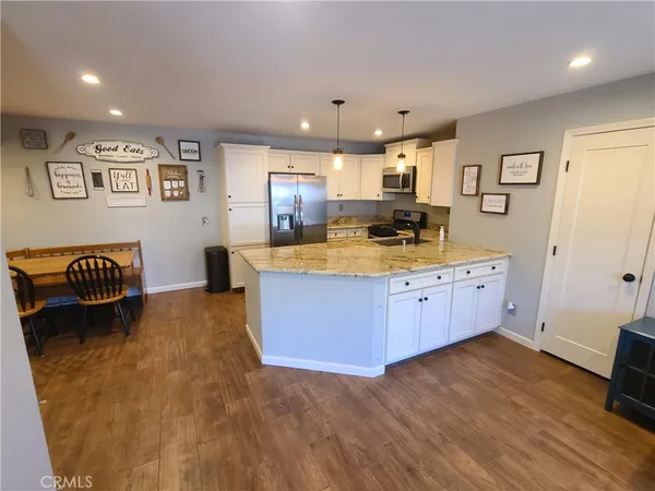 a large kitchen with stainless steel appliances granite countertop a large counter top a sink and a refrigerator