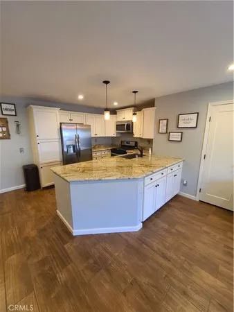 a large kitchen with stainless steel appliances a large counter top a stove and a sink