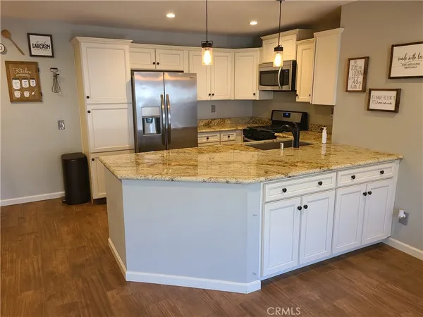 a kitchen with stainless steel appliances granite countertop a sink a stove and a refrigerator