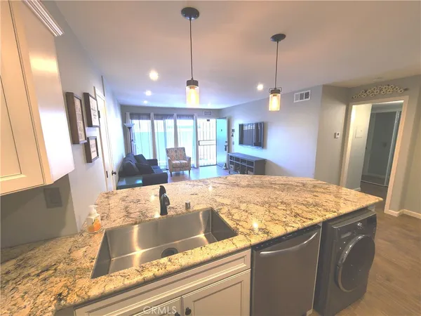 a view of a kitchen with granite countertop a sink and a wooden floor