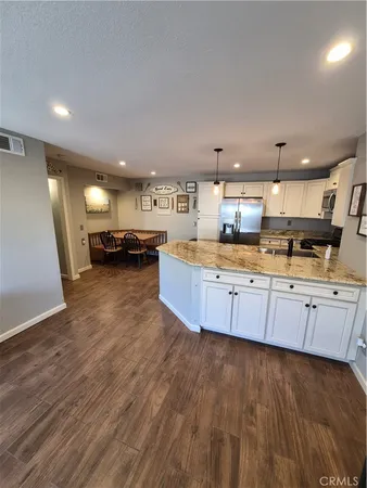 a large kitchen with stainless steel appliances a large counter top a stove and a sink
