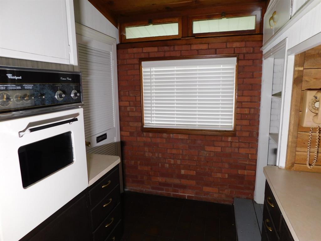 300 South Main Street Springhill, LA 71075 - Photo 18 of 35 a kitchen with granite countertop white cabinets and black appliances