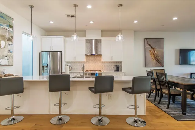 a kitchen with stainless steel appliances kitchen island granite countertop a table and chairs