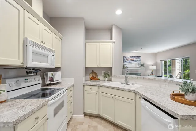 a kitchen with stainless steel appliances granite countertop a sink stove and cabinets