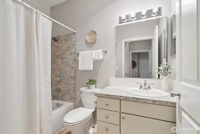 a bathroom with a granite countertop sink toilet a mirror and shower