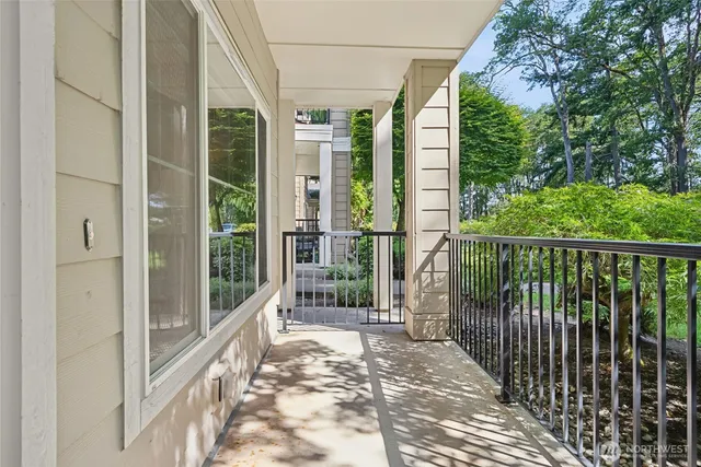 a view of a balcony with floor to ceiling windows and wooden fence