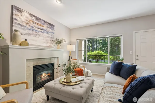 a living room with furniture a large window and a fireplace