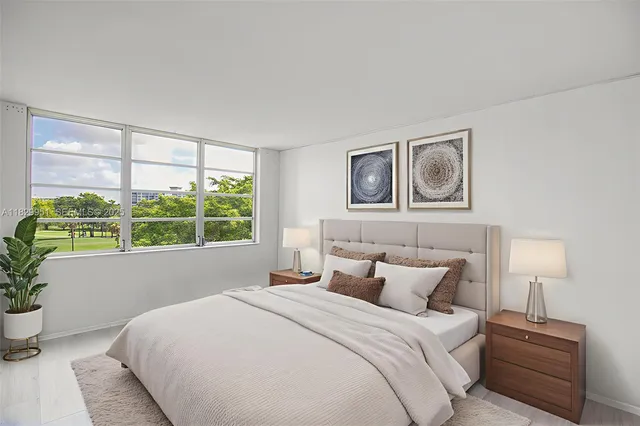 a large bed sitting in a bedroom next to a window
