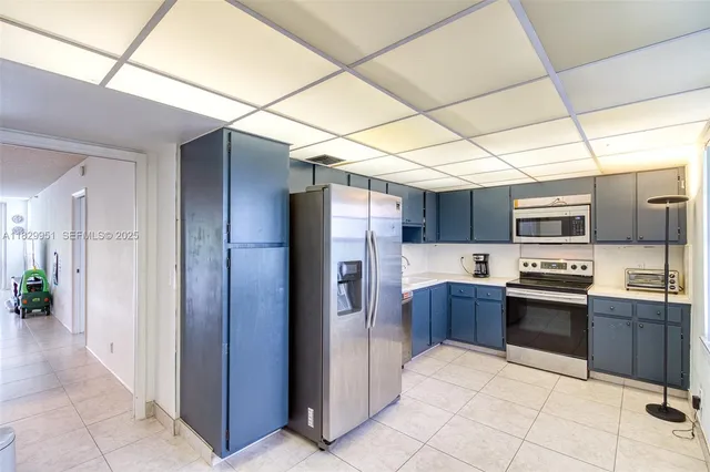 a large kitchen with stainless steel appliances granite countertop a refrigerator and a stove top oven