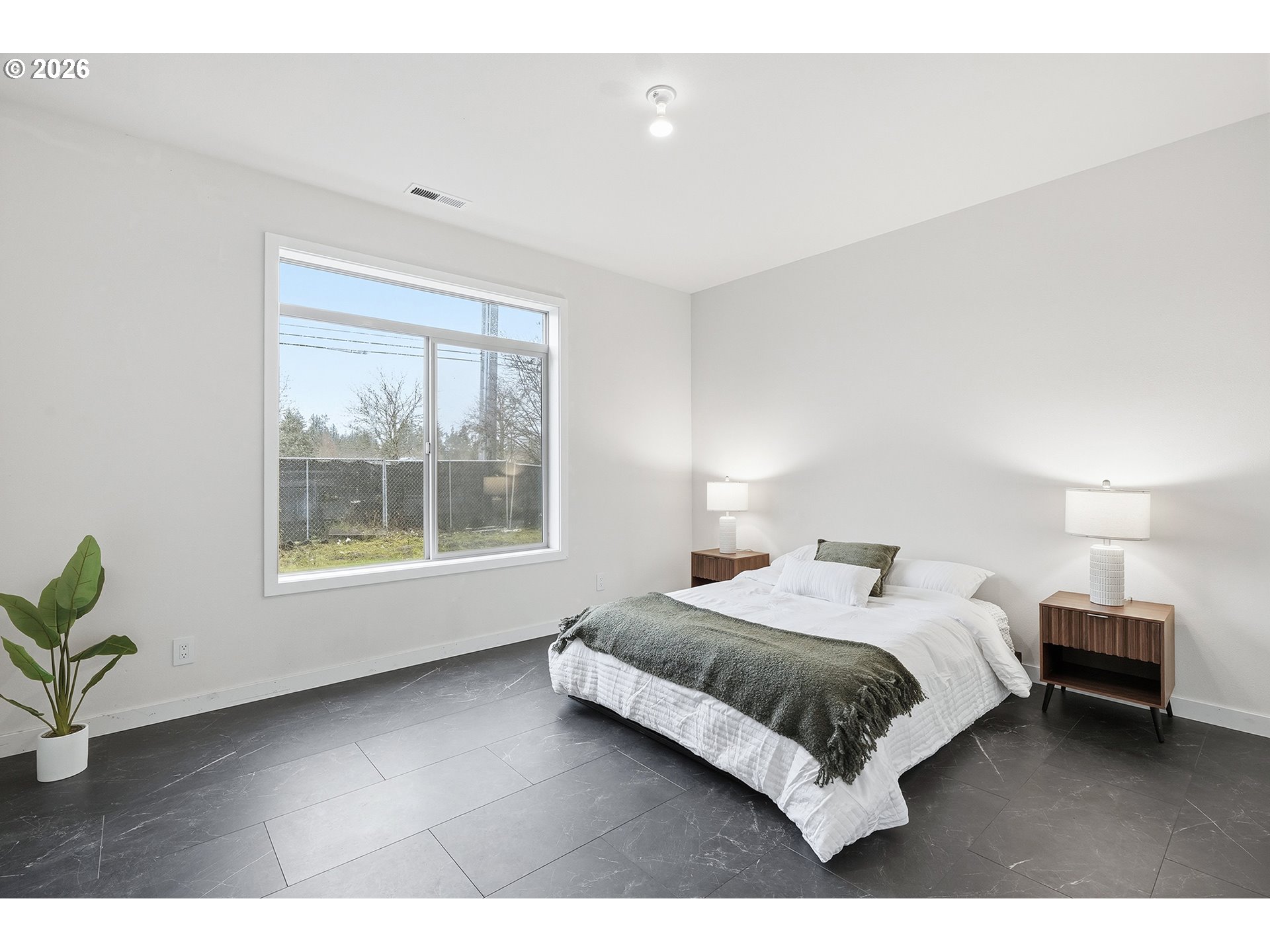 21280 Southwest Baseline Road Beaverton, OR 97003 - Photo 14 of 45 a bedroom with a bed lamp and a large window