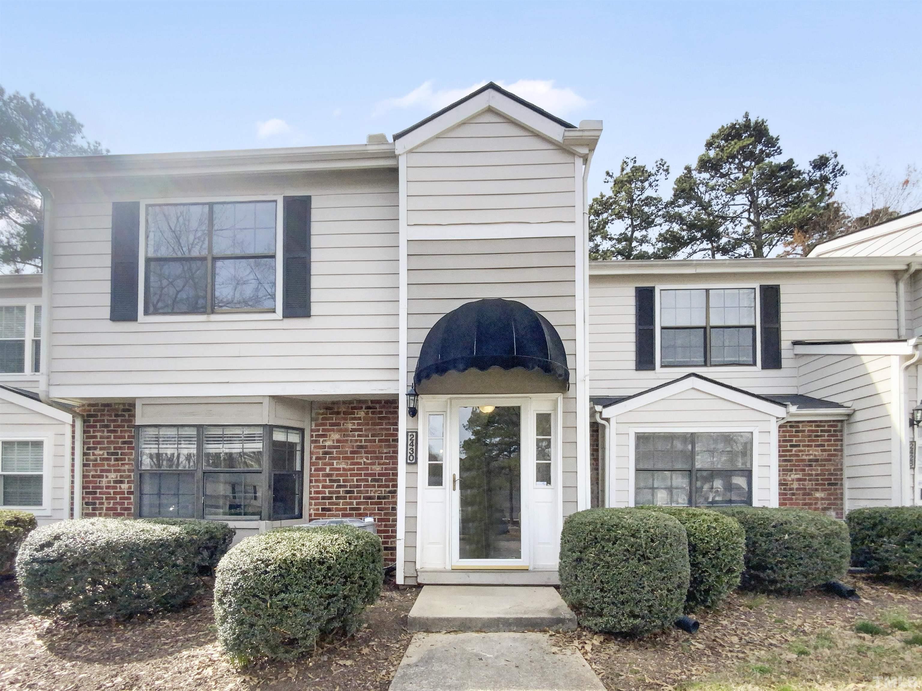 2430 Condor Court, Unit 2430 Raleigh, NC 27615 - Photo 1 of 19 a view of a white house with large windows and a yard