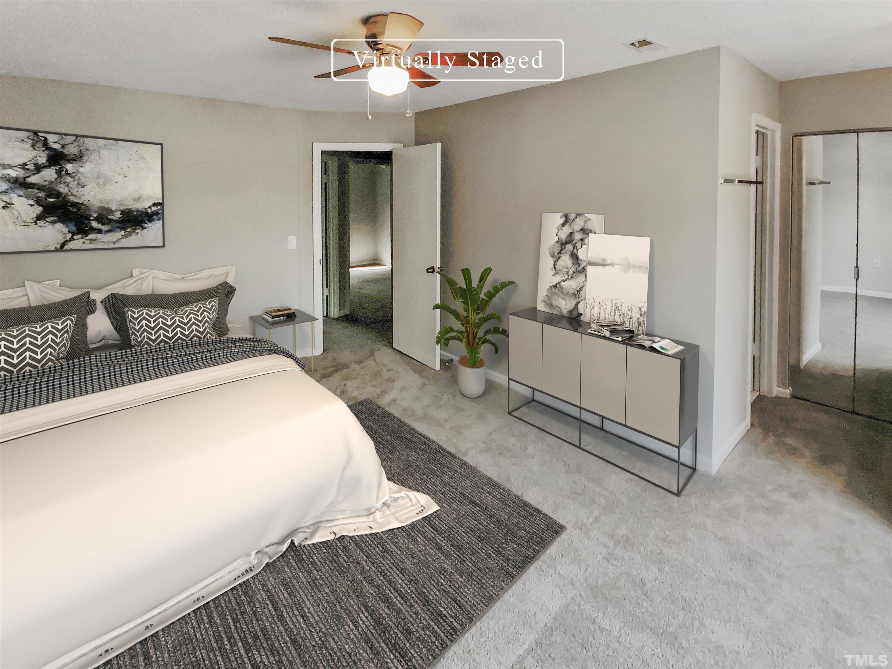 2430 Condor Court, Unit 2430 Raleigh, NC 27615 - Photo 4 of 19 a bedroom with a large bed and a chandelier