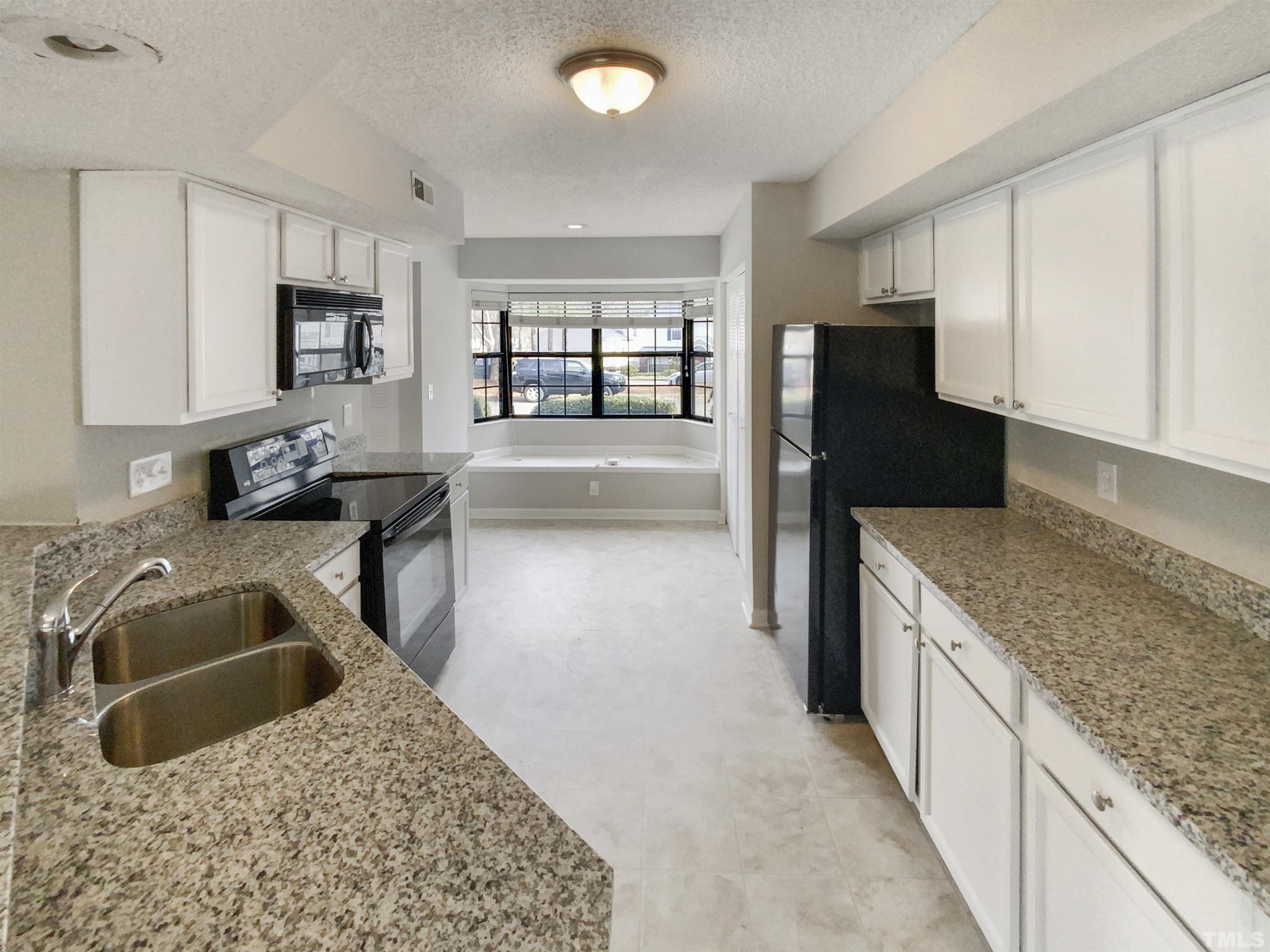 2430 Condor Court, Unit 2430 Raleigh, NC 27615 - Photo 10 of 19 a kitchen with stainless steel appliances granite countertop a sink stove and refrigerator