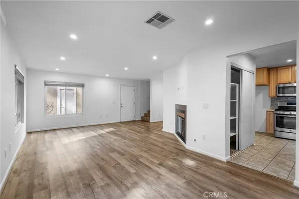 a view of empty room with wooden floor and window