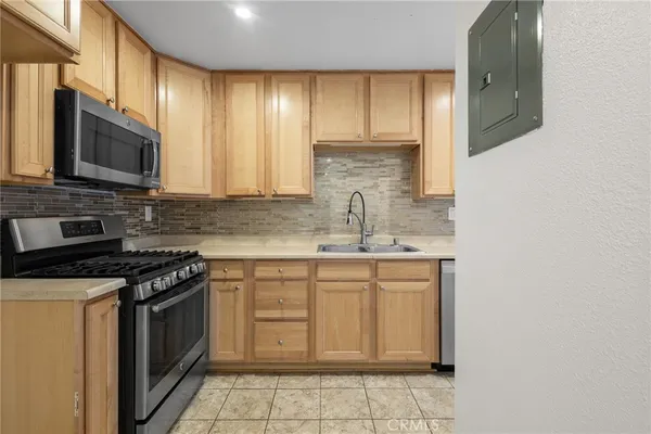 a kitchen with stainless steel appliances granite countertop a stove a sink and a microwave
