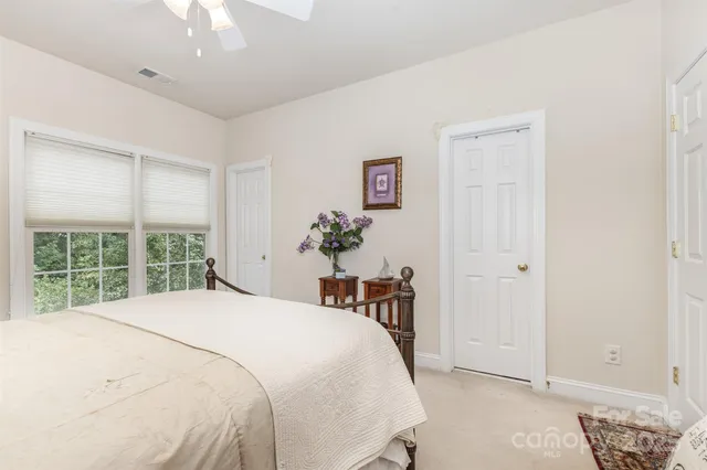 a bedroom with a bed table and a window