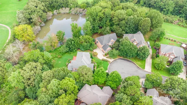 an aerial view of a house with a yard and lake view