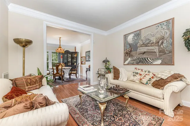 a living room with furniture and a painting on the wall