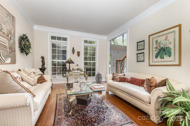 a living room with furniture large window and wooden floor