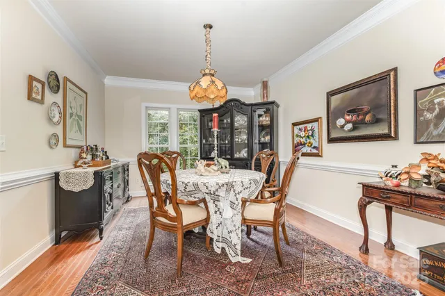 a dining room with furniture a chandelier and window