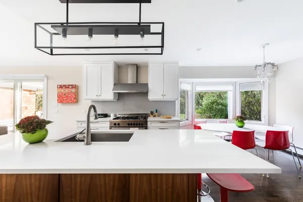 a kitchen with stainless steel appliances a sink a stove and a wooden floor