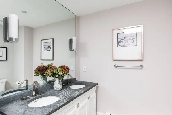 a bathroom with a granite countertop sink a mirror and vanity