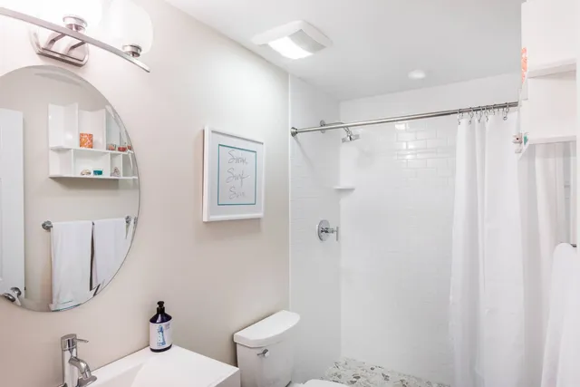 a bathroom with a sink mirror vanity and toilet