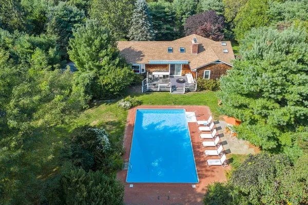 an aerial view of a house with swimming pool and big yard