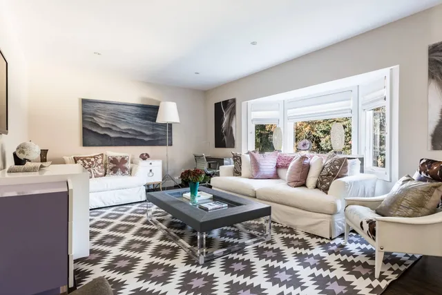 a living room with furniture a rug and a window