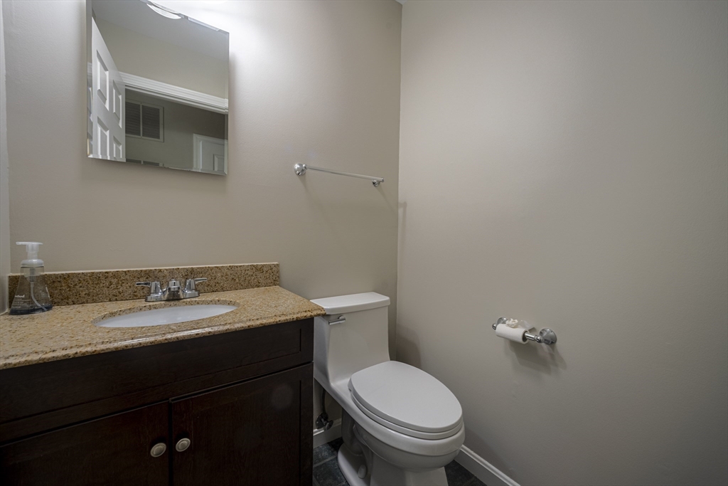 357 Boylston Street, Unit 3 Lowell, MA 01852 - Photo 27 of 35 a bathroom with a granite countertop toilet sink and mirror