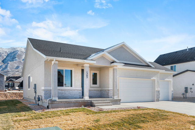 2823 North 710 West, Unit 16 Logan, UT 84321 - Photo 2 of 22 View of front facade featuring a front yard, a garage, covered porch, and stucco siding