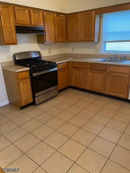 41 Wainwright Street Newark, NJ 07112 - Photo 6 of 7 a kitchen with granite countertop cabinets a sink and a stove