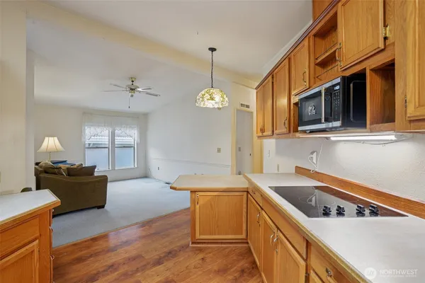 a kitchen that has a sink a stove and wooden floor