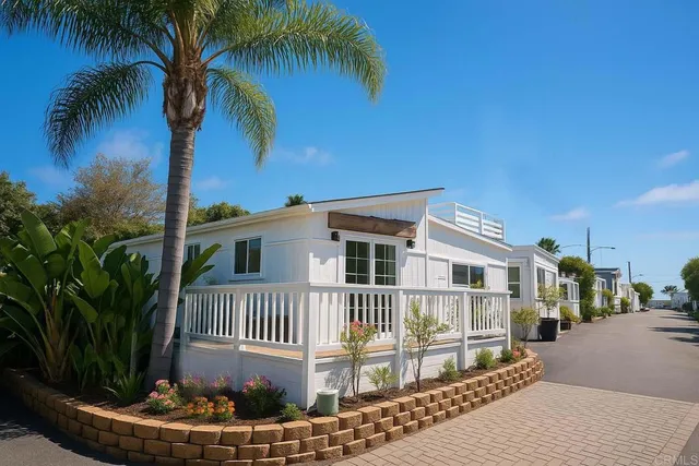 a view of a house with a yard and potted plants