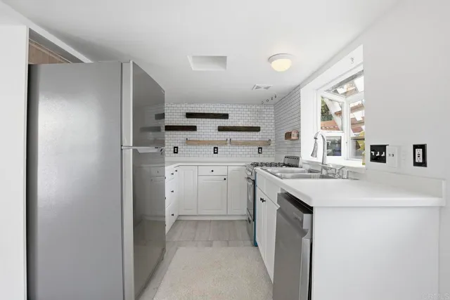 a kitchen with white cabinets and refrigerator