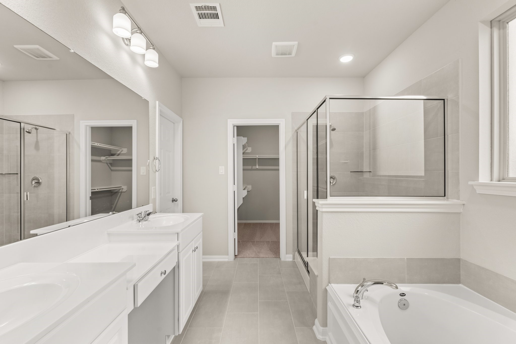 3228 Bright Maple Drive Conroe, TX 77385 - Photo 9 of 22 a bathroom with a tub a sink and mirrors