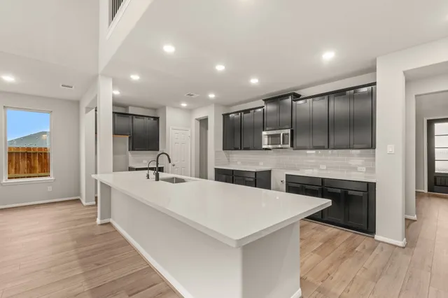 a view of large kitchen with stainless steel appliances cabinets