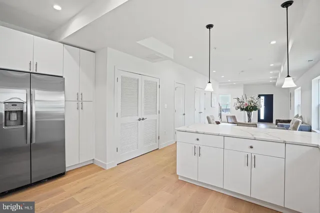 a kitchen with white cabinets and refrigerator