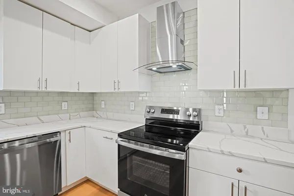 a kitchen with a stove and white cabinets