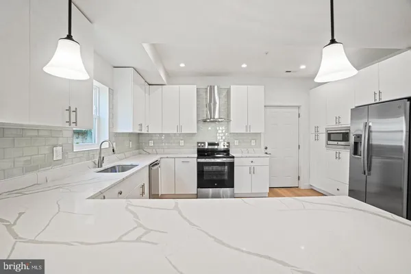 a kitchen with granite countertop a sink and stainless steel appliances