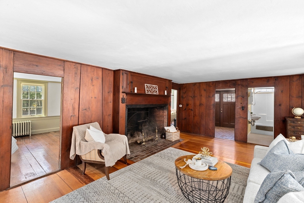385 Whiting Street Hanover, MA 02339 - Photo 7 of 42 a living room with furniture a fireplace and wall paintings