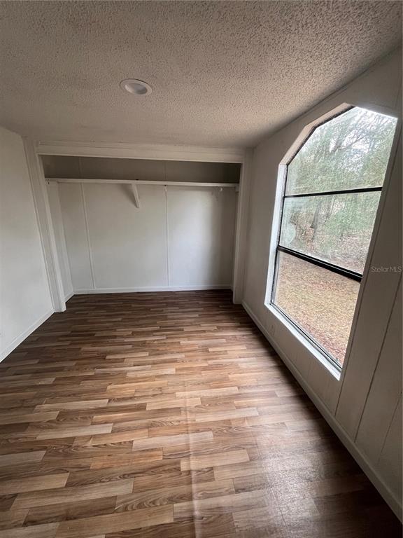 10330 Northeast 90th Street Bronson, FL 32621 - Photo 21 of 31 a view of room with window and wooden floor