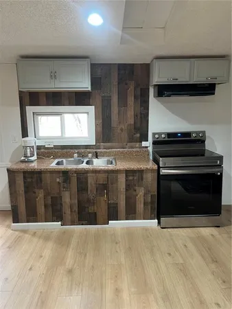 a kitchen with stainless steel appliances a stove a sink and a microwave