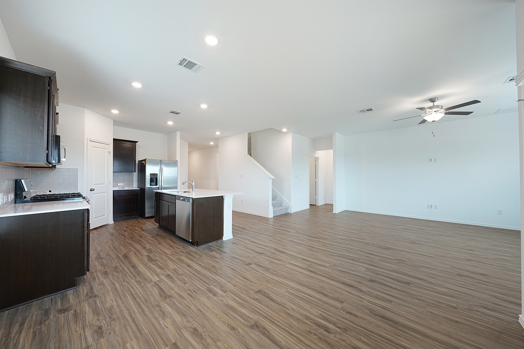 932 Mallow Road Leander, TX 78641 - Photo 21 of 34 A fluid layout seamlessly connects kitchen and living areas, offering effortless movement throughout.
