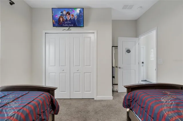 a bedroom with a large bed and a chandelier